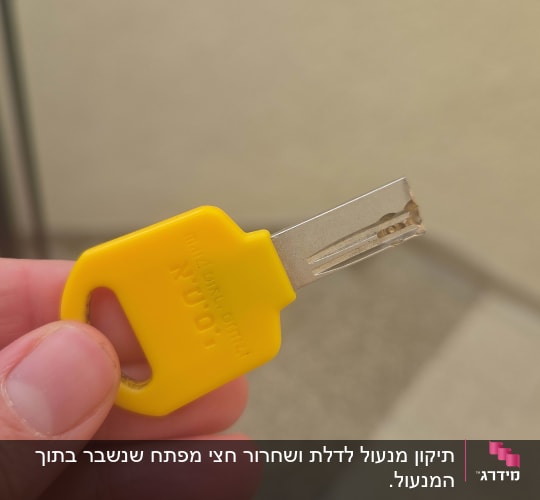 מפתח צהוב מוחזק ביד על רקע מטושטש